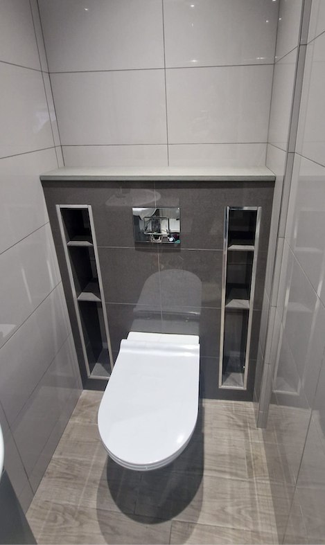 Grey bathroom with recessed storage by AG Signature Renovation